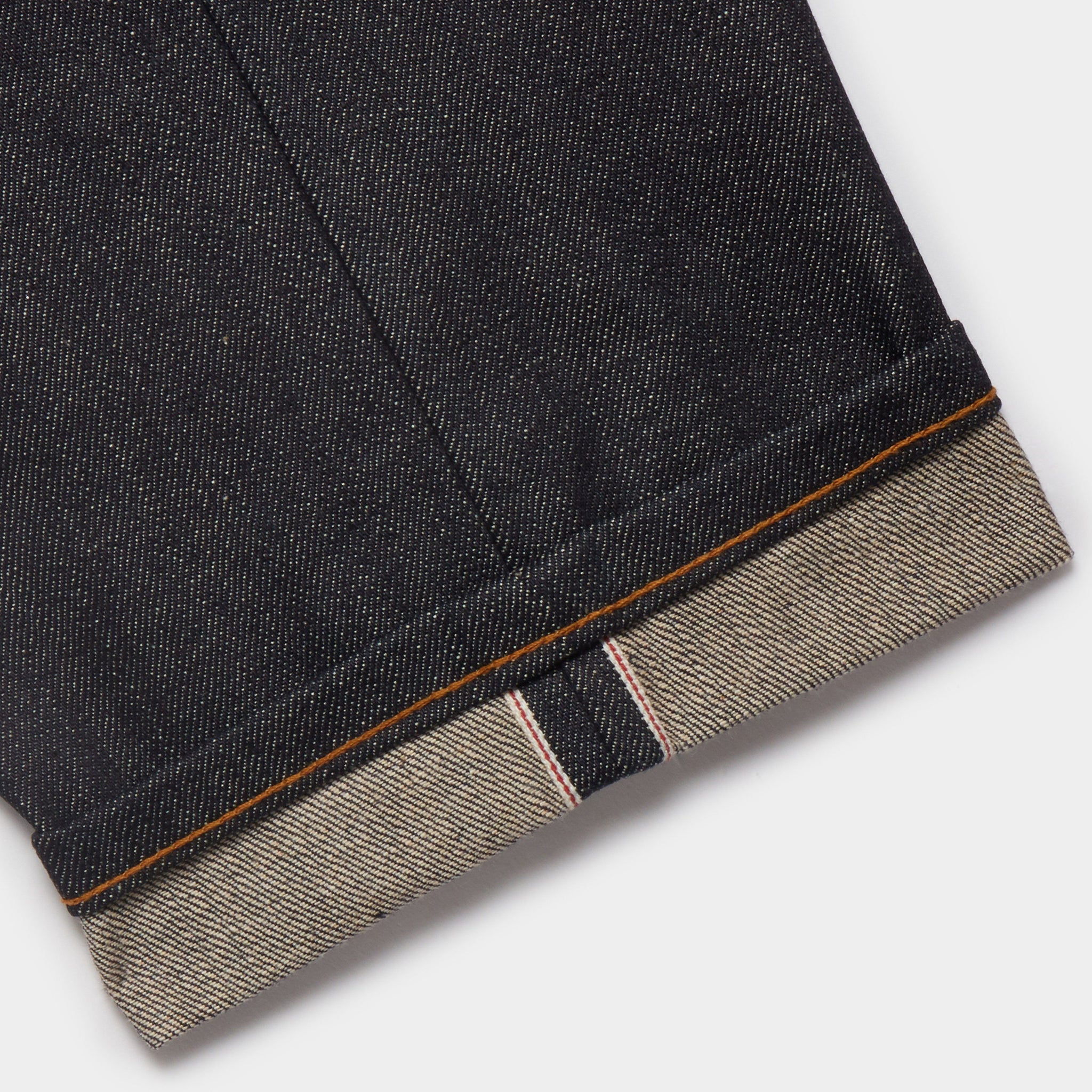Loose Tapered Japanese Selvedge Jeans (Indigo) - Kaihara Jeans HAWKSMILL DENIM CO. Selvedge and turn up close up. Raw denim. Red and white selvedge made on antique shuttle looms in Japan. Chain stitch from vintage Union Special machine.
